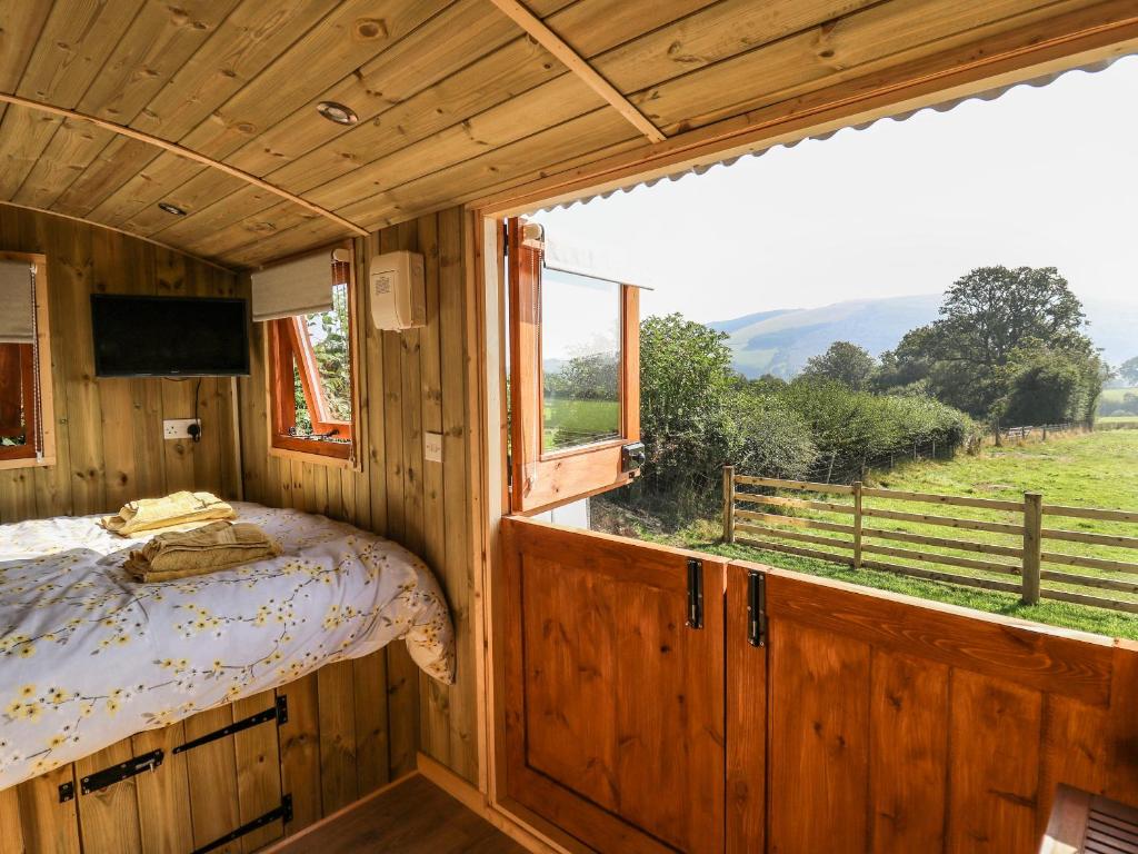 1 dormitorio con cama y ventana grande en Elan, en Llandrindod Wells