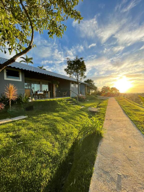 een huis aan de zijkant van een veld met zonsondergang bij Pousada Terraço Guarapari in Guarapari