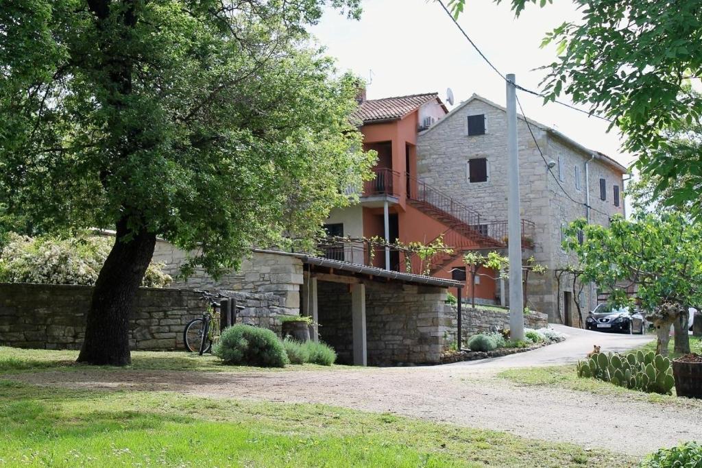 a house with a tree next to a street at Apartments Mestri in Grožnjan