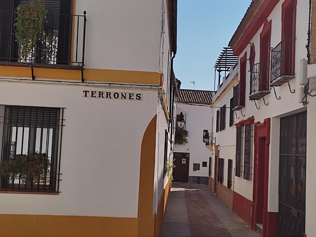 Une allée dans une ville avec un panneau indiquant les ternesos dans l'établissement San Basilio´s Red House, à Cordoue