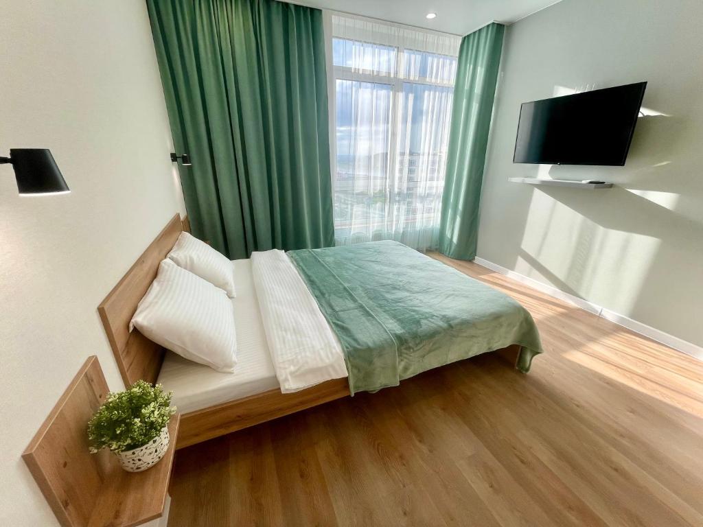 ein kleines Schlafzimmer mit einem Bett und einem Fenster in der Unterkunft HomeHotel in Kemerowo