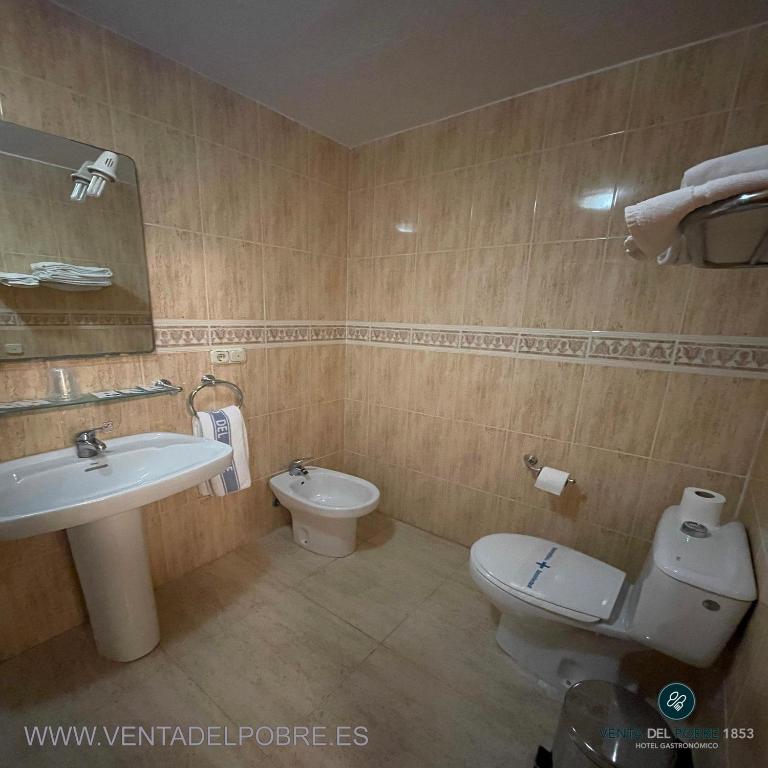 Łazienka z białą toaletą i umywalką w obiekcie Hotel Venta del Pobre w mieście Níjar