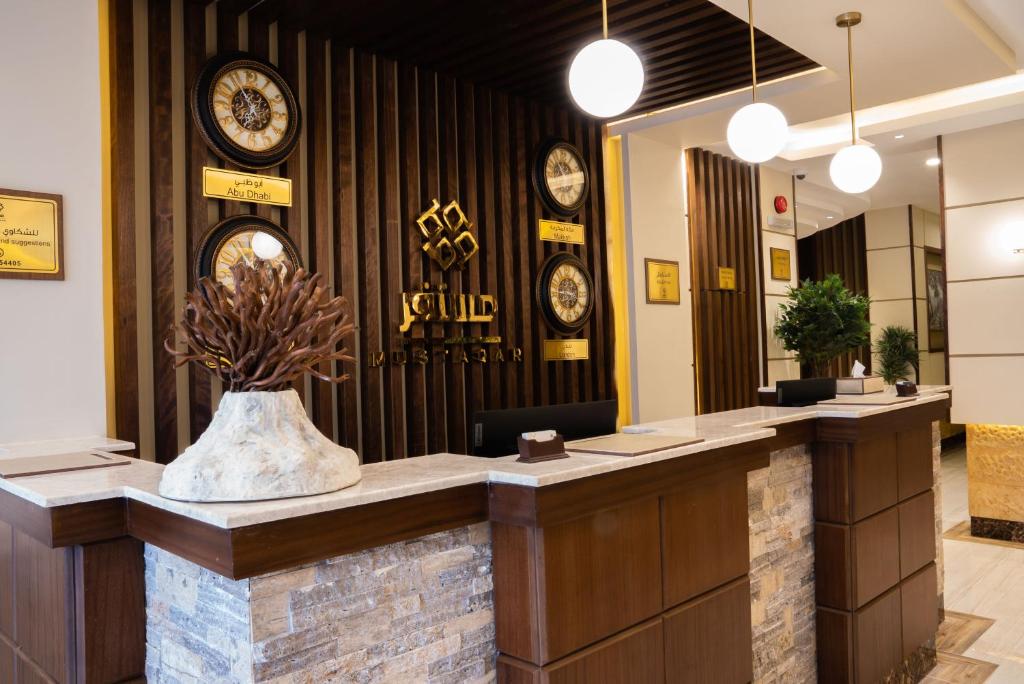 a lobby with a counter with clocks on the wall at مستقر للشقق الفندقية - النقرة in Hail