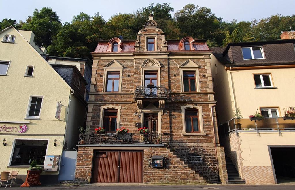 an old brick building with a balcony on a street at Ehemaliges Winzerhaus Cochem in Cochem