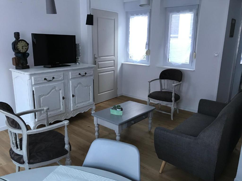 sala de estar con TV, sofá y mesa en Le saint Pierre, en Roye
