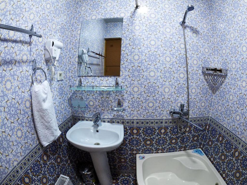 布哈拉的住宿－NABIBEK Terrace，蓝色和白色的浴室设有水槽和卫生间