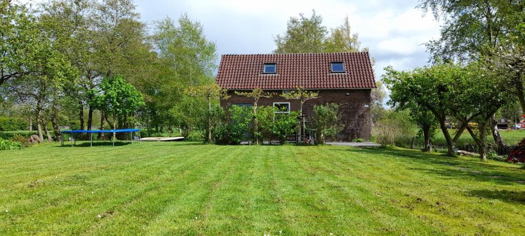 una casa con un gran patio delante de ella en Huisje Beukers, en Giethoorn