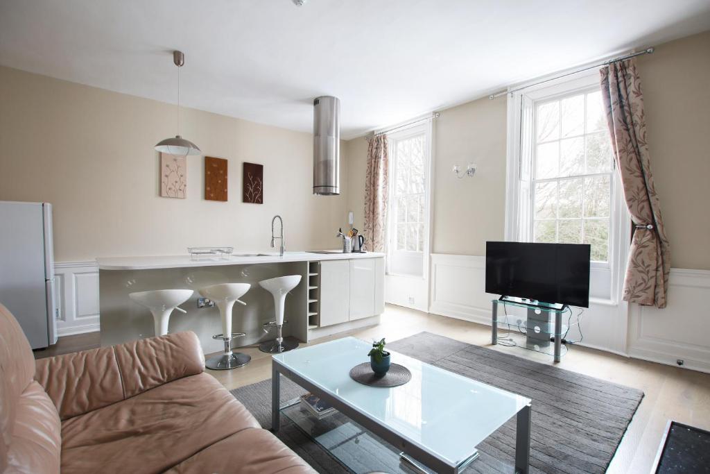 a living room with a couch and a table at Elegant Georgian apartment near Clifton Village in Bristol