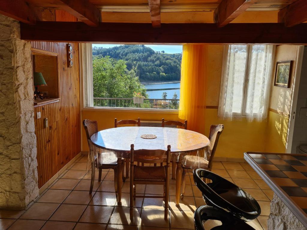 een eetkamer met een tafel en stoelen en een raam bij Serenity- le clos du Patou in Mont-Roc