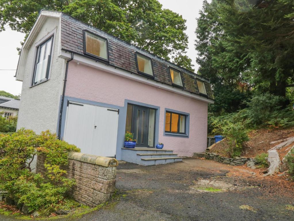 a small pink house with a white garage at Dunaivon Cottage in Helensburgh