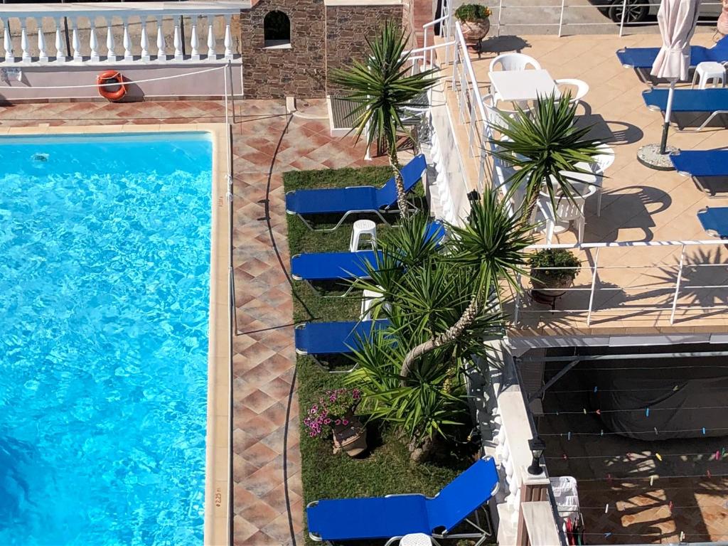 una vista aérea de una piscina con sillas y palmeras en Villa Mary 1 & fresh!, en Skala Sotiros