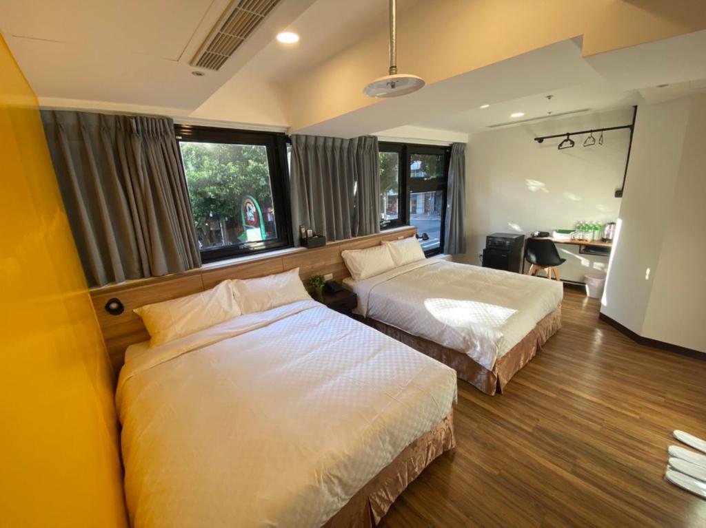 台北的住宿－悦心旅Yesing Hotel，一间卧室配有两张床和一张书桌