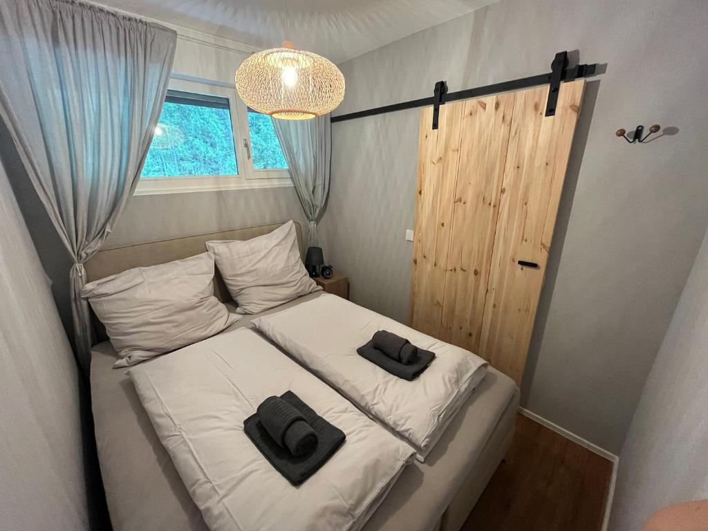 a bedroom with a bed with two black pillows on it at BLACKFOREST LOFT - Panoramablick Schwarzwald in Schonach