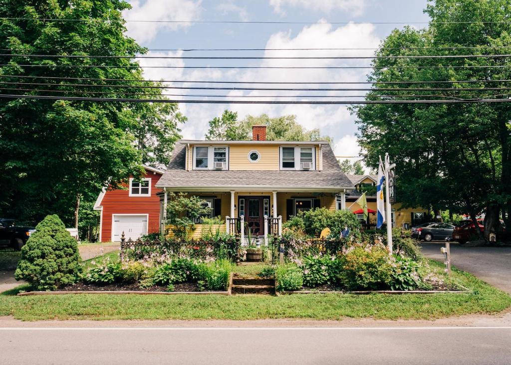 a house with flowers in the front yard at Farmhouse Inn B&B in Canning