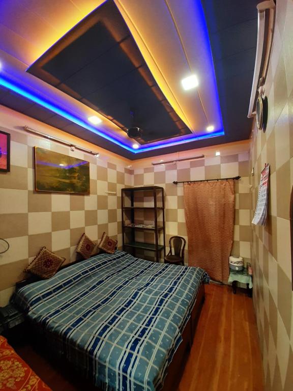 a bedroom with a bed with blue lights on the ceiling at Jagan Hotel & Restaurant in Dhaulpur