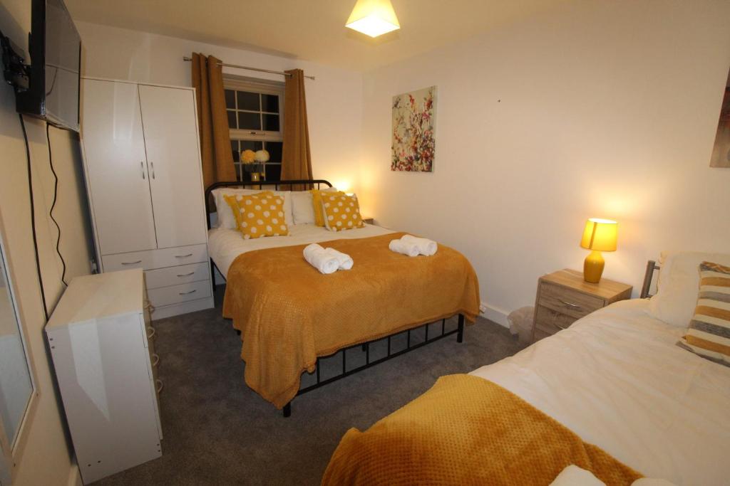 a bedroom with two beds with towels on the bed at Pavement House in Sutton in Ashfield