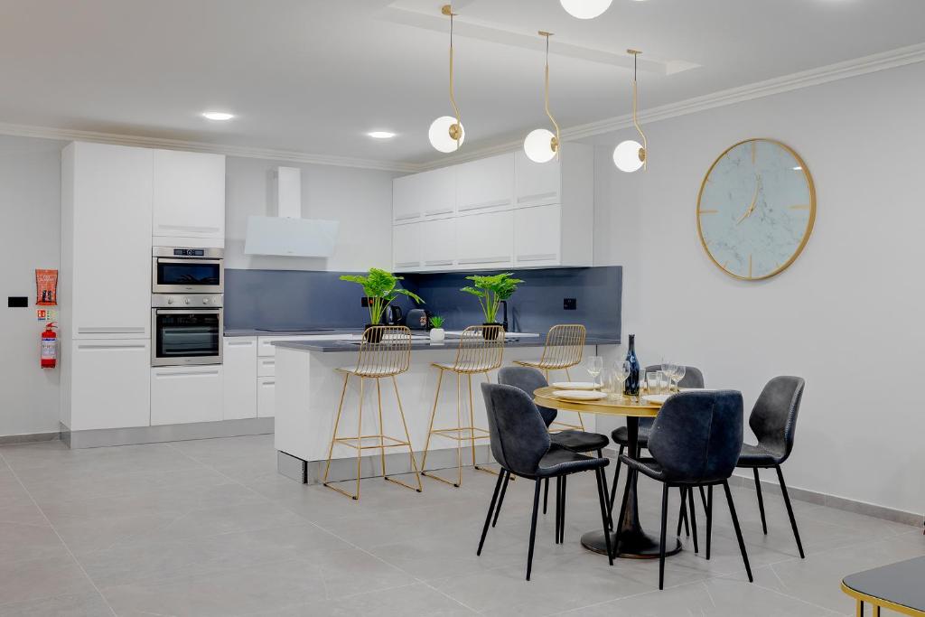 a kitchen with a table and chairs and a counter at Art Deco Luxury Apartment, Central Location in Sliema