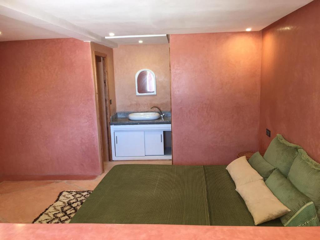 um pequeno quarto com um sofá e uma cozinha em L'abri côtier de Dar Nezza em Sidi Kaouki