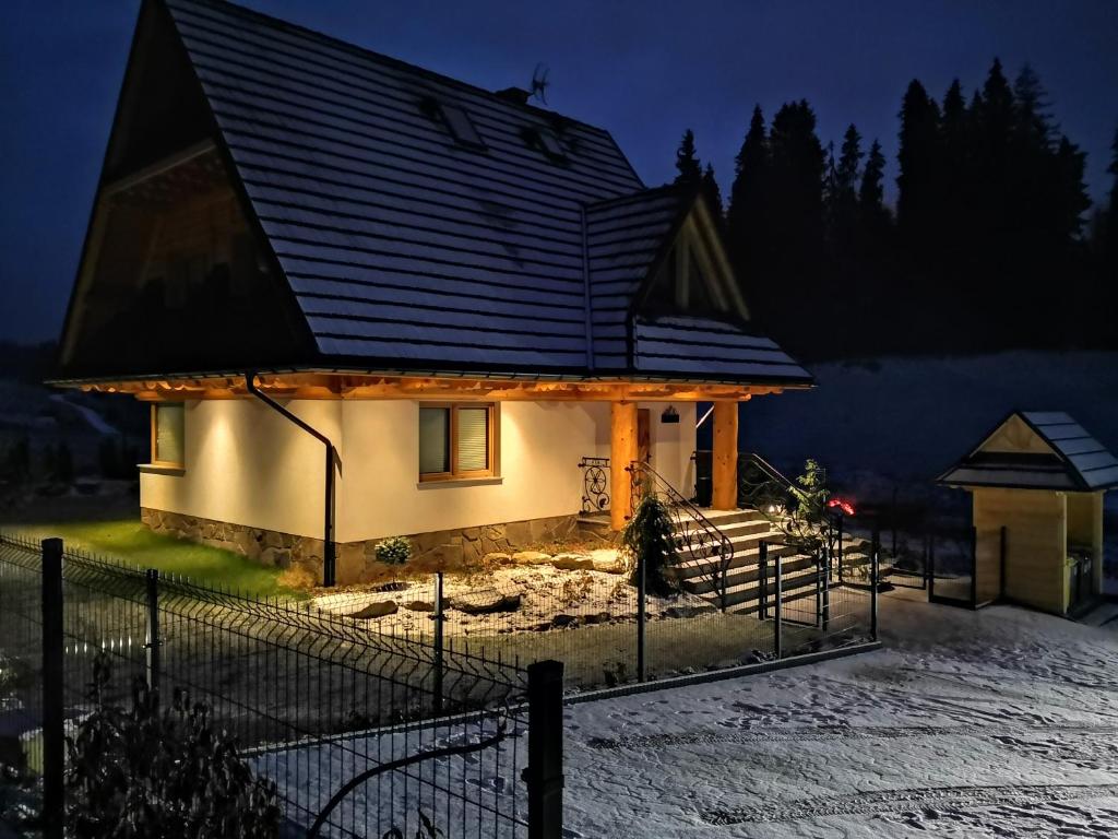 a house in the snow at night at Dom między górami in Bukowina Tatrzańska
