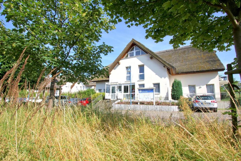 a white house with a car parked in front of it at F-1010 Strandhaus Mönchgut Bed&Breakfast DZ 23 Terrasse, strandnah, inkl Frühstück in Lobbe