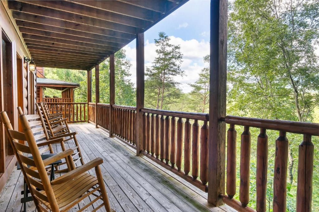 a porch with rocking chairs and a view of the woods at Lux Spa Cabin, Sauna, HotTub, Indoor Pool, Mins to PF in Sevierville