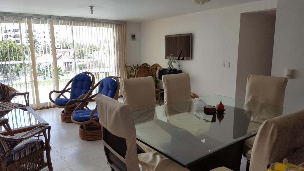 comedor con mesa de cristal y sillas en Apartamento Edificio Sea View, en San Andrés