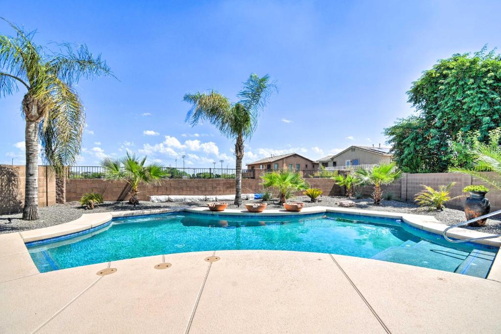 een zwembad in een tuin met palmbomen bij Arizona Villa with Pool Walk to Surprise Stadium! in Surprise
