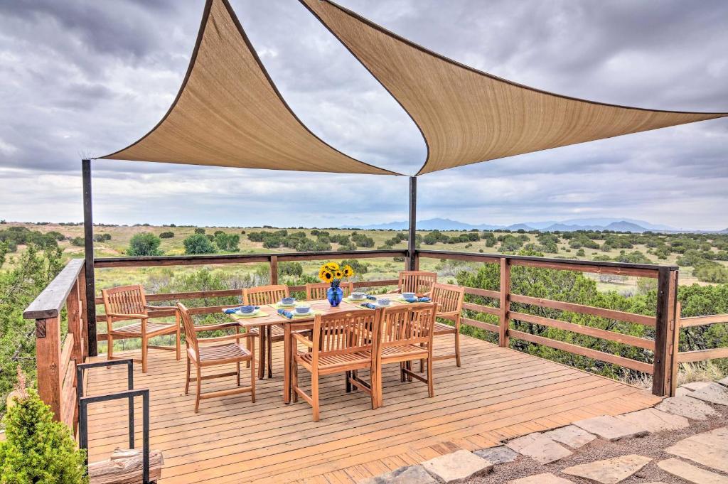 a wooden deck with a table and chairs on it at Dreamy Santa Fe Hideaway with Mountain Views! in Santa Fe