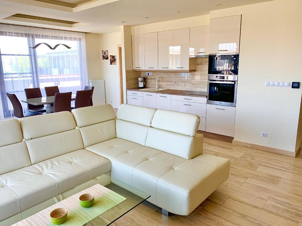 Il comprend un salon avec un canapé blanc et une cuisine. dans l'établissement Lakeview apartment with big terrace, à Zamárdi