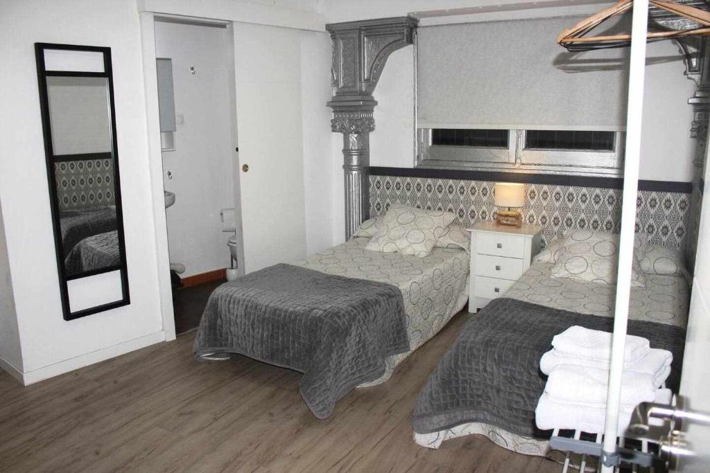 a bedroom with two beds and a mirror at Moderno apartamento en el corazón de Madrid Sol in Madrid