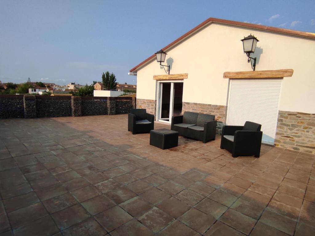 a patio with three chairs and a building at Casa Rural Maño in Deltebre