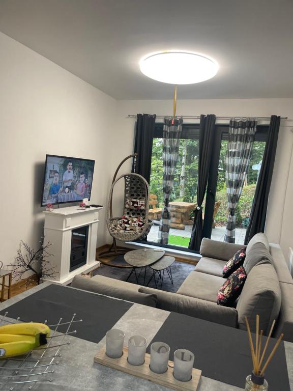 ein Wohnzimmer mit einem Sofa und einem TV in der Unterkunft Bjelasnica White apartmani in Bjelašnica