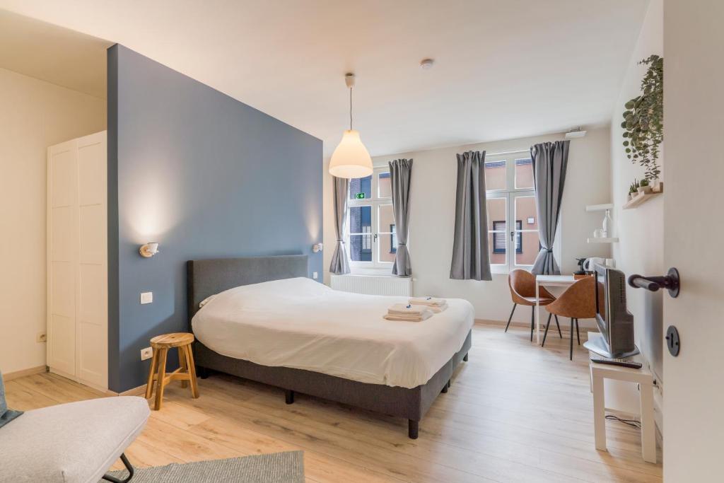 a bedroom with a bed and a table and chairs at De Hoogmolen - 3 mins from the city centre in Bruges