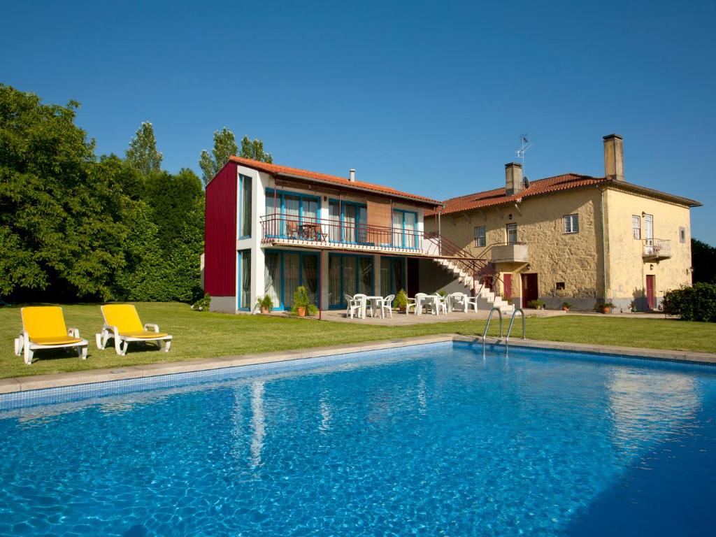 a house with a swimming pool in front of a house at Quinta do Casal de S. Miguel de Soutelo in Vila Verde