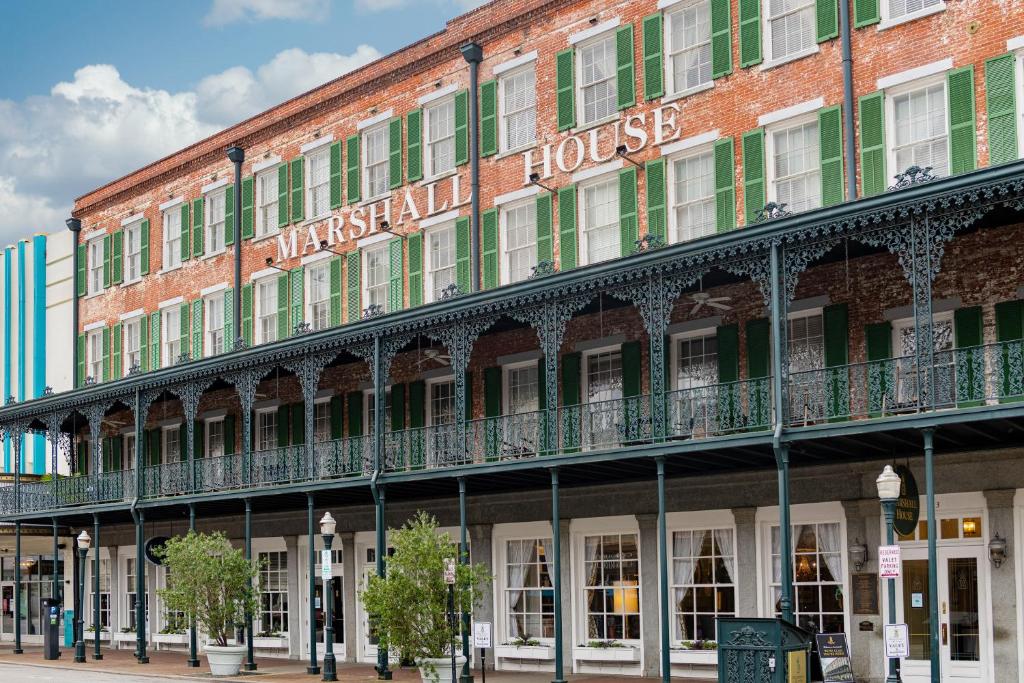 a large brick building with a sign on it at The Marshall House, Historic Inns of Savannah Collection in Savannah