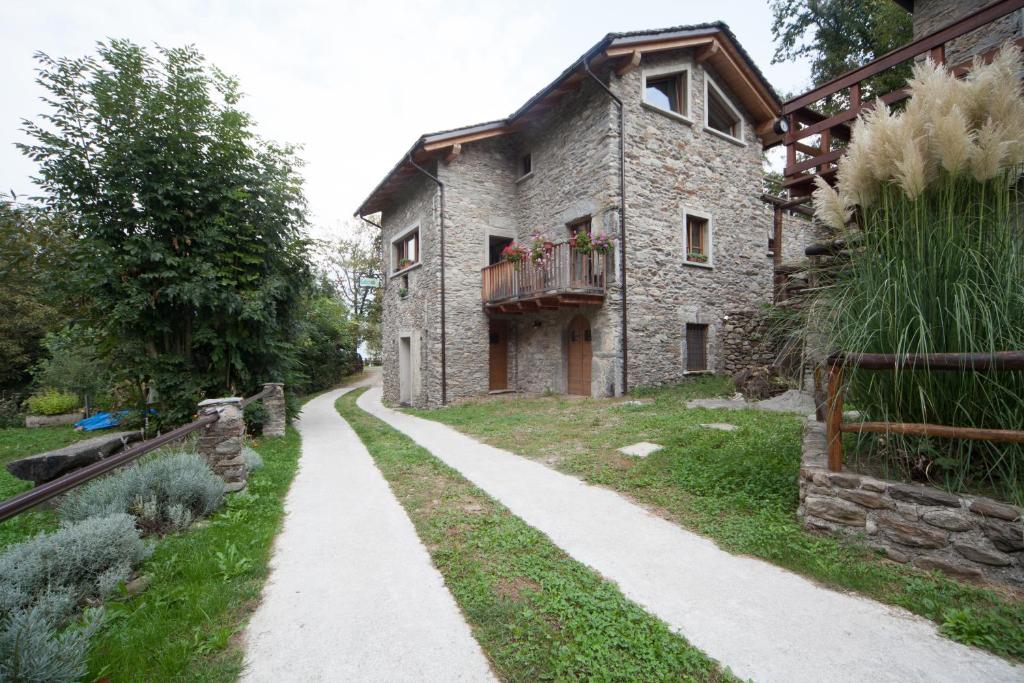 een oud stenen huis met een pad ervoor bij Agriturismo L'Eco in Morbegno