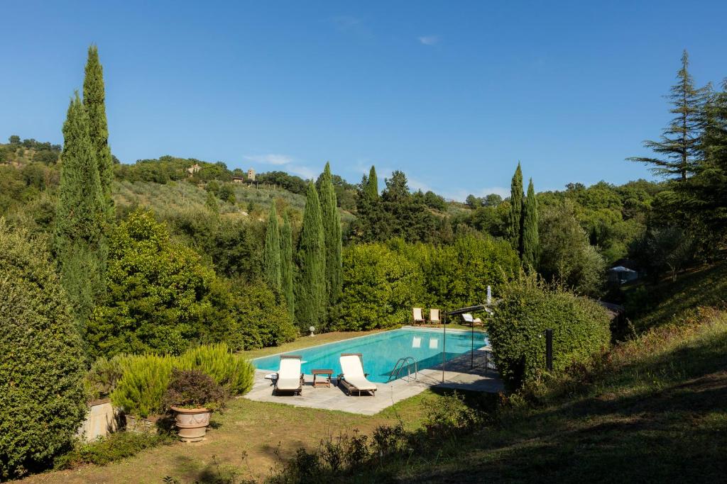 a swimming pool in a garden with two lounge chairs at Monteaperto in Barberino di Mugello