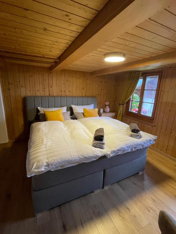 ein Schlafzimmer mit einem großen Bett in einem Zimmer in der Unterkunft Charmant Chalet mit See und Bergsicht in Hofstetten 