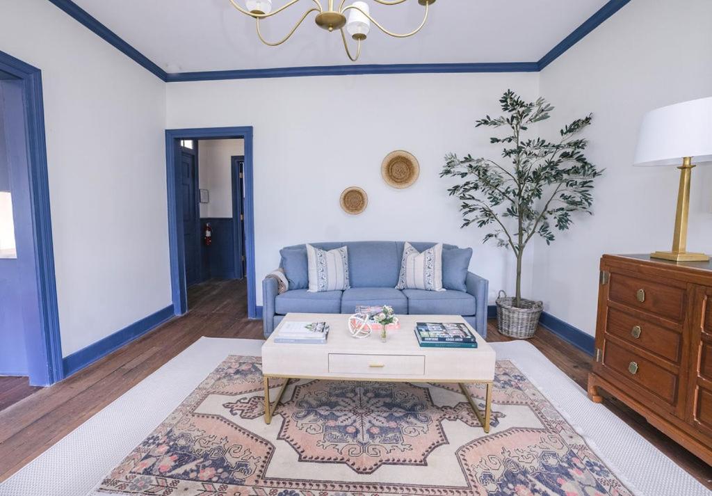 a living room with a blue couch and a coffee table at Guesthouse Charleston EAST 42 C in Charleston