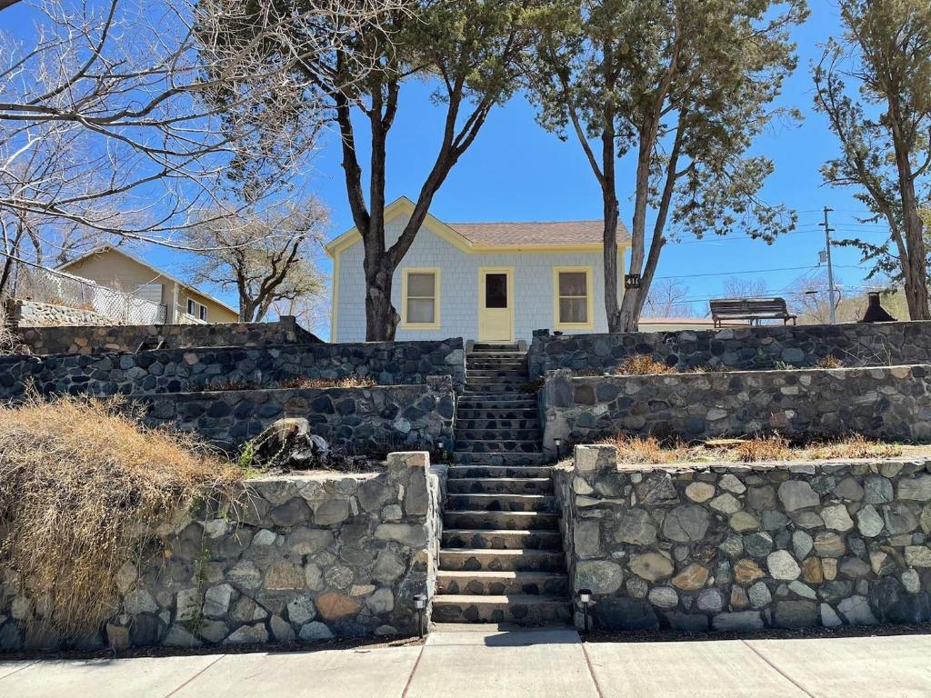 a stone retaining wall with stairs in front of a house at 7min Walk to Courthouse Plaza! Historic Cottage in Prescott