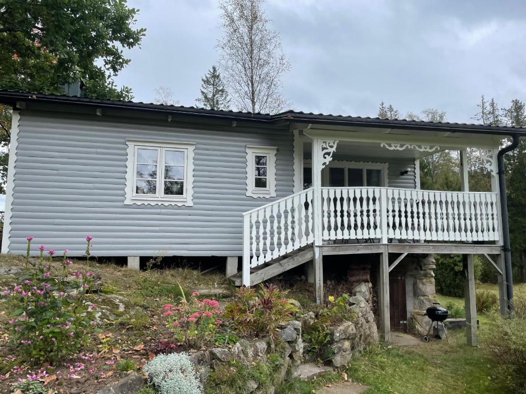 Casa azul pequeña con porche y balcón en Berget en Skillingaryd