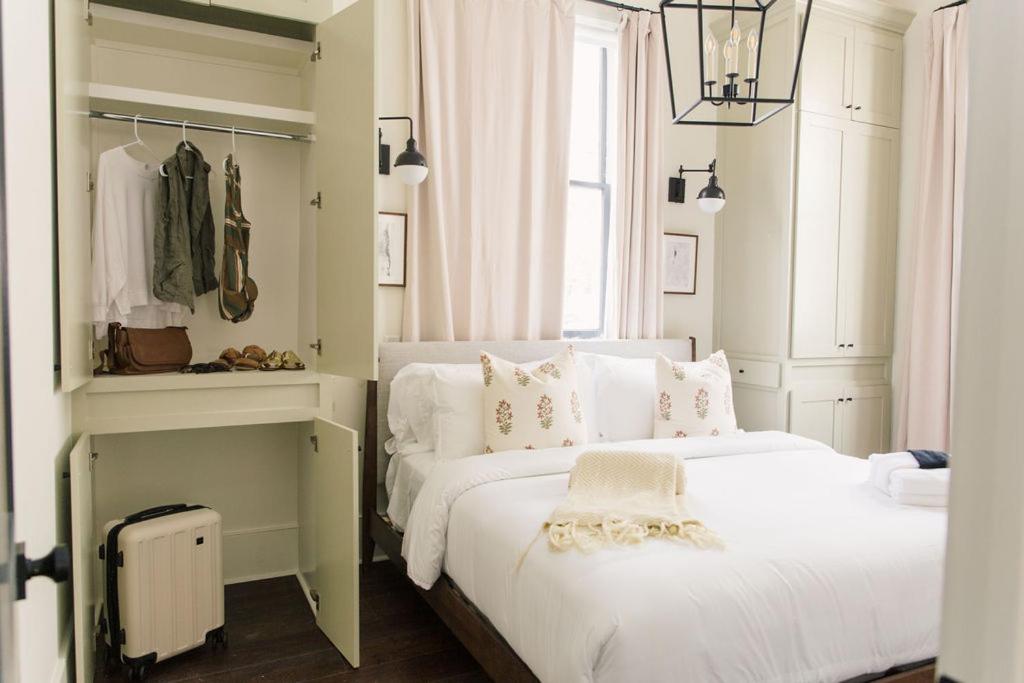 a bedroom with a white bed and a closet at Guesthouse Charleston EAST 46 E in Charleston