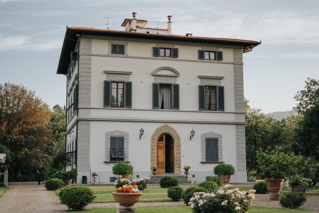 a large white house with black shutters at Villa Teresa in Cavriglia