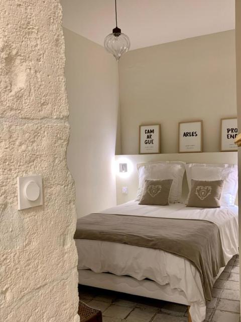 - une chambre blanche avec un lit et deux oreillers dans l'établissement L'oustaou d'Arles, à Arles