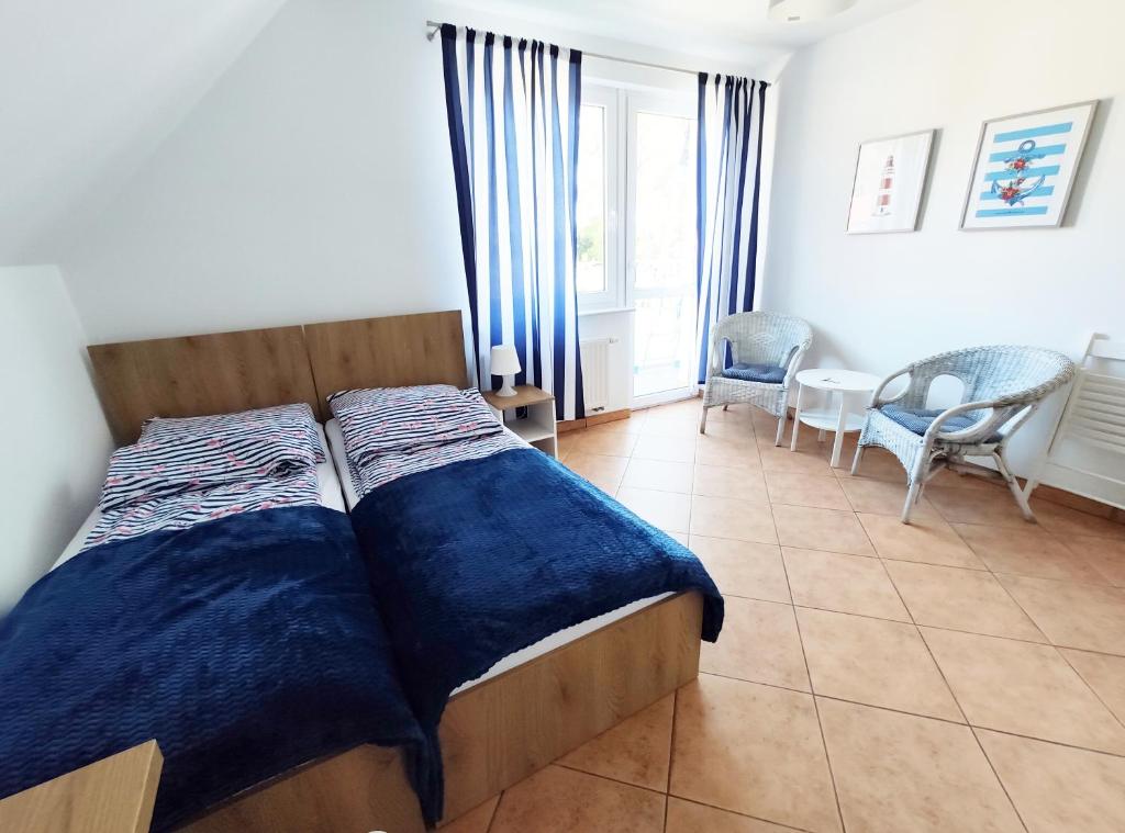 sypialnia z łóżkiem z niebieską pościelą w obiekcie Willa Nord w mieście Pustkowo