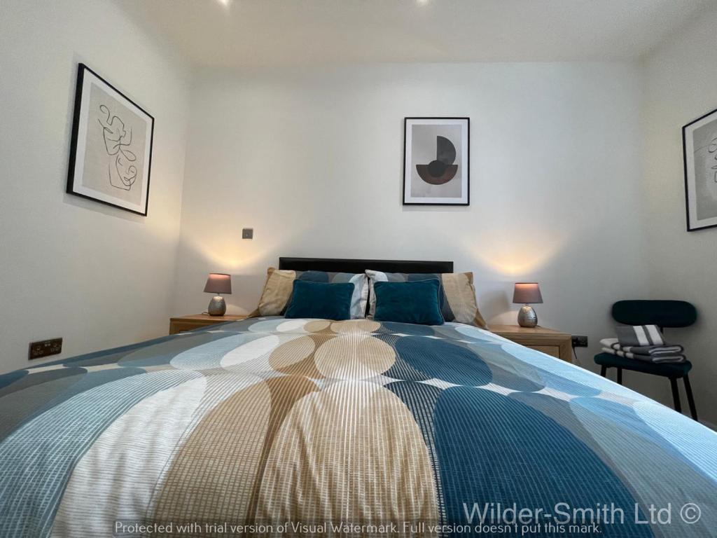 um quarto com uma cama grande e almofadas azuis em Central Nottingham Gem - Luxurious 2-Bed Apartment em Nottingham