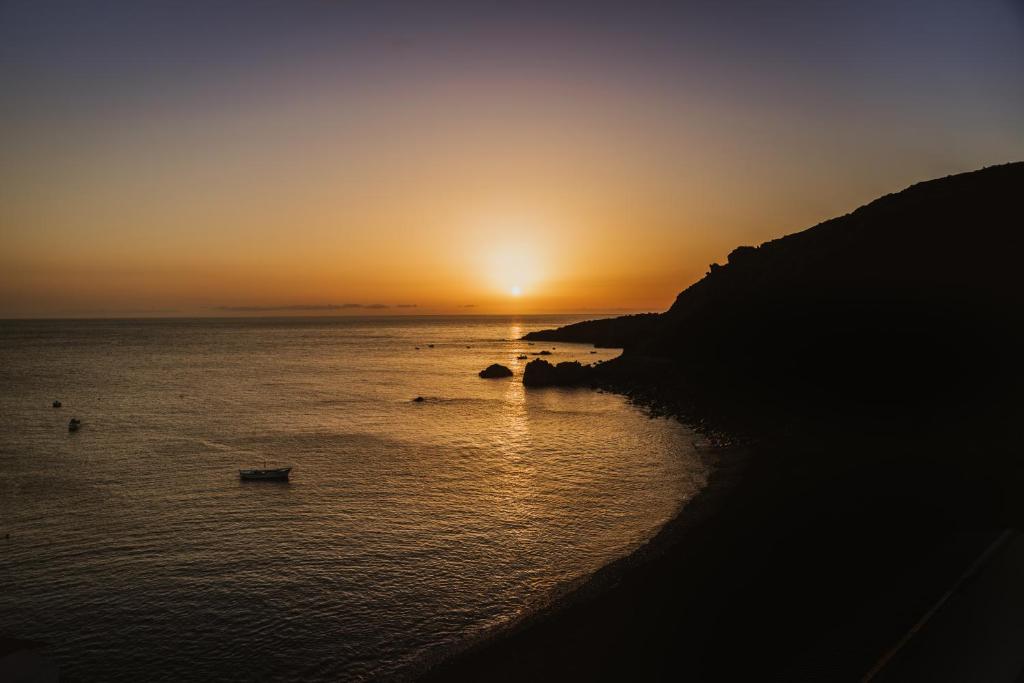 a sunset over the ocean with boats in the water at Mirador del Atlántico in Los Quemados