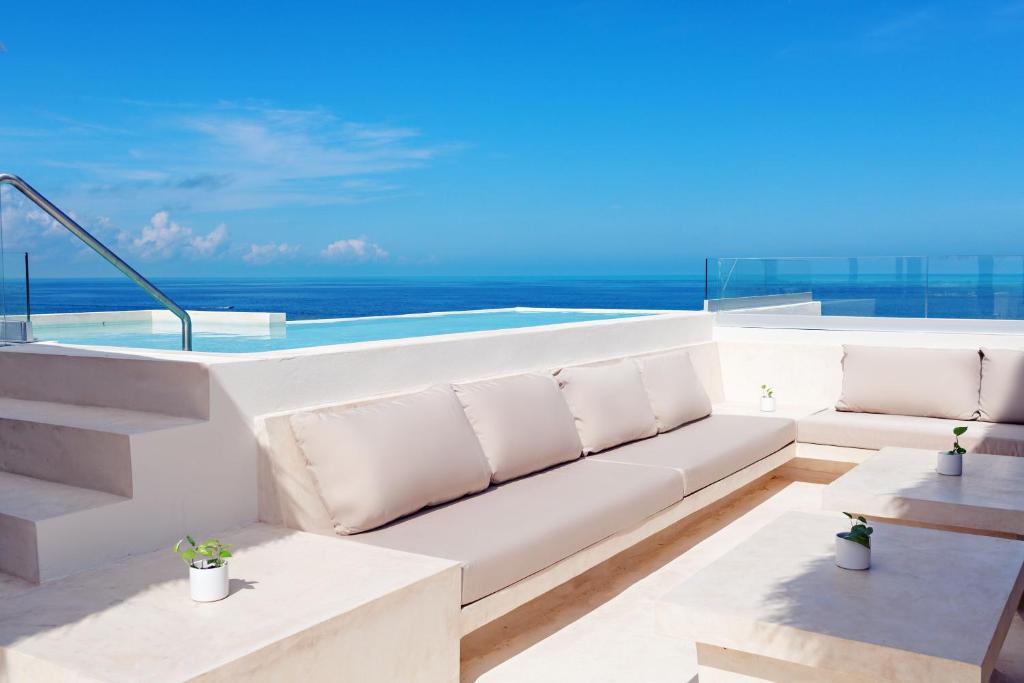 a living room with a couch and a view of the ocean at Casa Astral Luxury Hotel in Holbox Island