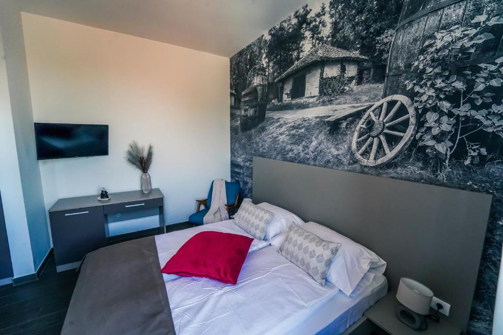 1 dormitorio con 1 cama con una pintura en la pared en Bagrina Suites en Belgrado