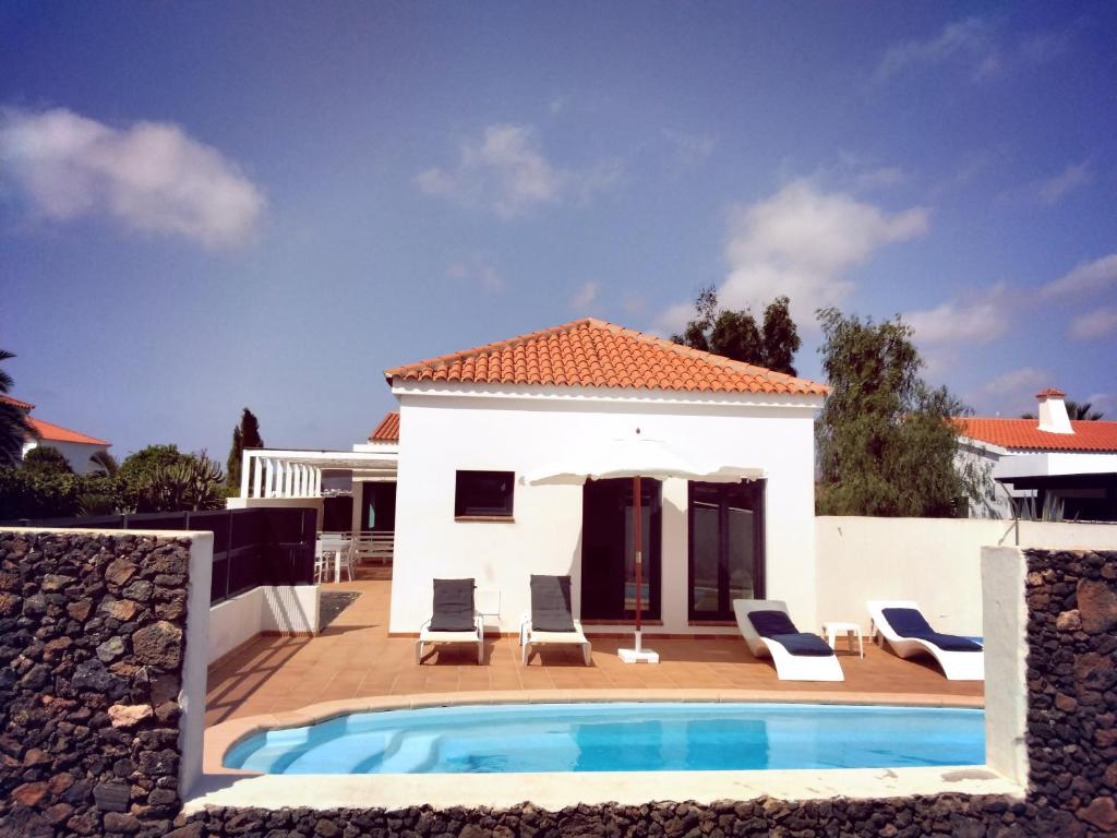 une villa avec une piscine et une maison dans l'établissement SURFWHITEHOUSE, à Lajares